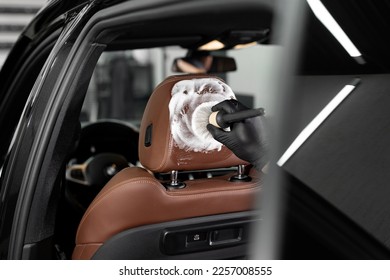 Washing with foam with a brush of the interior, leather car seats. Car detailing service - Shutterstock ID 2257008555
