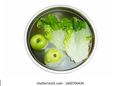 Washing fresh vegetables and fruit in bowl with water in clipping path