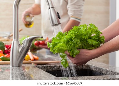 Washing fresh vegetables for a salad with an alive oil - Powered by Shutterstock