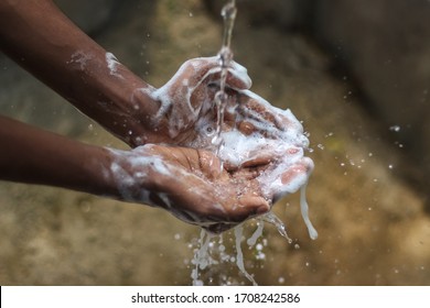 Washing hands.Man washing his hands in the garden at home. Coronavirus pandemic prevention wash hands with soap warm water and , rubbing nails and fingers washing frequently. Hygiene & Cleaning Hands.