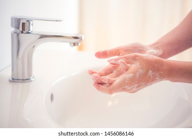 Washing hands with soap under the faucet with water. Hygiene concept. - Shutterstock ID 1456086146