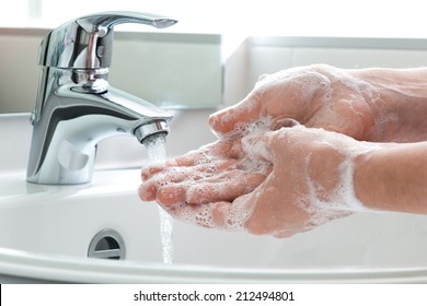 Washing of hands with soap under running water - Shutterstock ID 212494801
