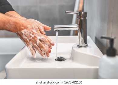 Washing hands with soap and warm water for 20 seconds for corona virus COVID-10 prevention. Work man for corona virus hygiene to stop spreading coronavirus. - Shutterstock ID 1675782136