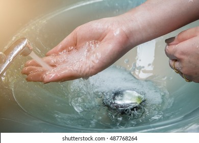 Washing Hands Under Flowing Tap Water Flow On Sink