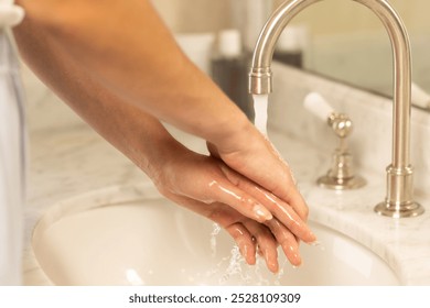 Washing hands under running water in bathroom sink for hygiene. cleanliness, handwashing, health, soap, sanitation, prevention - Powered by Shutterstock