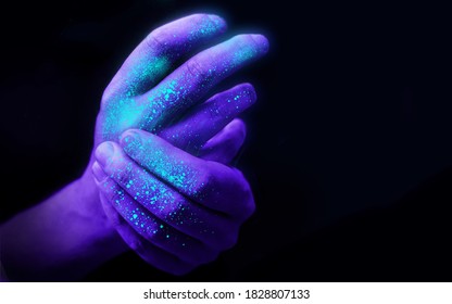 Washing Hands In UV Ultra Violet Light Illustrating Bacteria And Viruses On Hands And The Importance Of Good Hygiene. Covid 19 Pandemic Concept.