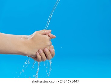 Washing hands with water on blue background.