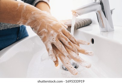 Händewaschen Frau Spülseife mit fließendem Wasser am Spülbecken, Coronavirus 2019-Ncov Vorbeugung Handhygiene. Korona Virus Pandemie Schutz durch häufige Reinigung der Hände.