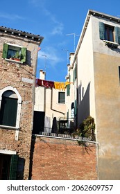 Washing Lines In An Alley In Venice, Italy. Laundry Hanging On A Clothes Line Between City Buildings. Clothes Lines Between Old Brick Houses.