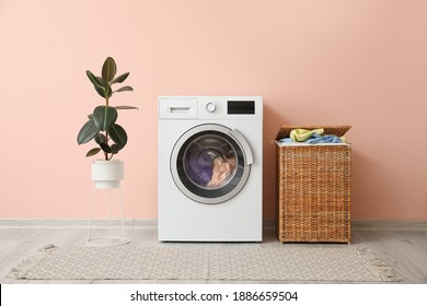Washing machine and basket with laundry near color wall - Shutterstock ID 1886659504