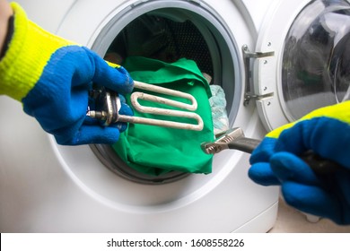 washing machine breakdown. The master retrieves the floor part. In the hands of a spiral and adjustable spanner. Close-up. - Powered by Shutterstock