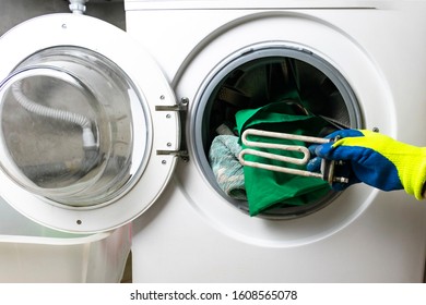 washing machine breakdown. The master retrieves the floor part. In the hands of a spiral and adjustable spanner. Close-up. - Powered by Shutterstock