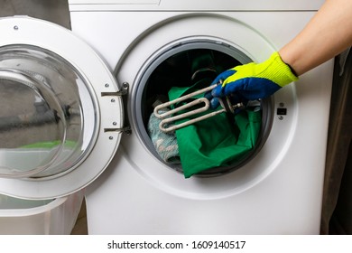 washing machine breakdown. The master retrieves the floor part. In the hands of a spiral and adjustable spanner. Close-up. - Powered by Shutterstock