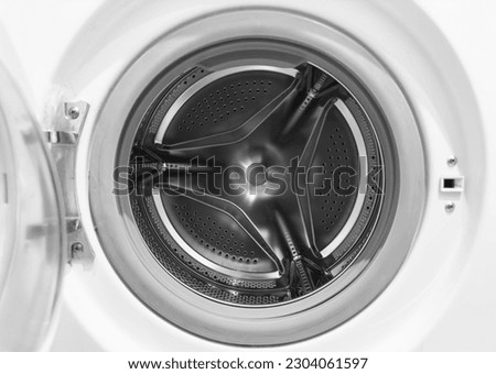 Washing machine drum close up. Washing machine background. Inside the washing machine. Metal washing machine drum. Perforated shiny metal