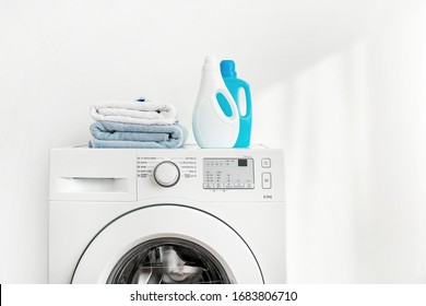 Washing machine, washing gels and clean bath towels on white background