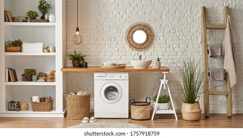 Washing Machine In The Laundry Room, Wooden Table And Shelf Style, Sink Lamp Mirror And Wicker Basket Decor Object.