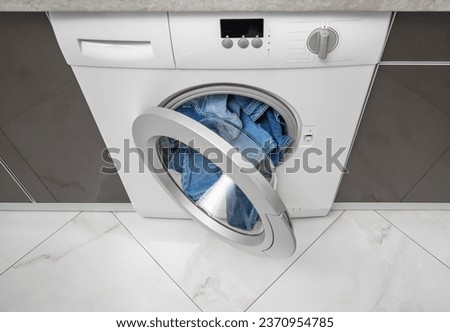 Washing machine overflowing with clothes. Wrong wash.