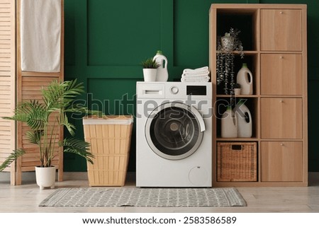 Washing machine, shelving unit, and laundry basket near green wall in room