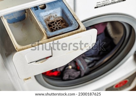 Washing machine.Dirty moldy washing machine detergent and fabric conditioner dispenser drawer compartment close up. Mold and dirt in washing machine.
