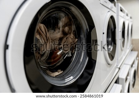 Washing machines, tumble dryer in a laundromat. industrial laundry equipment, energy efficient appliances, commercial laundry solutions, sustainable washing technology, hygienic washing environment