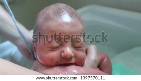 Similar – Newborn in the bathtub with her mother washing her hair