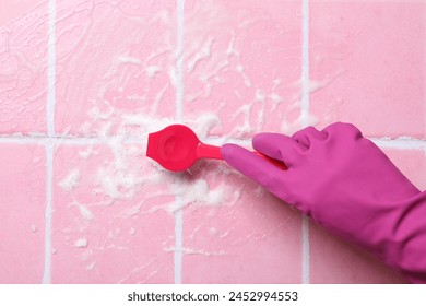 Washing pink tiles in rubber gloves close-up - Powered by Shutterstock