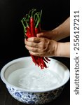 Washing Sichuan Erjingtiao red chili peppers placed in a blue and white porcelain basin in China