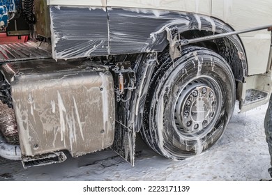 Washing truck wheels with foam solution - Shutterstock ID 2223171139