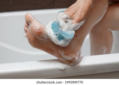 Washing your feet. Sponge with foam. Wash in the bathroom - Shutterstock ID 1995909770