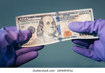 WASHINGTON DC - APRIL 5 2020:  
$100 bill held by protective gloves. The Treasury Department and IRS announced coronavirus stimulus checks as part of the government economic impact payment package. 