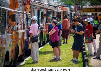 WASHINGTON DC - AUGUST, 2018: Customers Order From Colorful Food Trucks Selling A Variety Of International Cuisines Lined Up On The Mall.