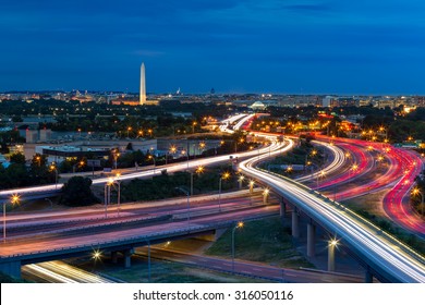 Washington D.C. cityscape at dusk with rush hour traffic trails on I-395 highway. Washington Monument, illuminated, dominates the skyline. - Powered by Shutterstock