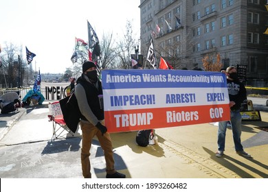 Washington, DC – January 13, 2021: Activists at Black Lives Matter Plaza holding a sign calling for Trumps impeachment, arrest or expulsion from office.