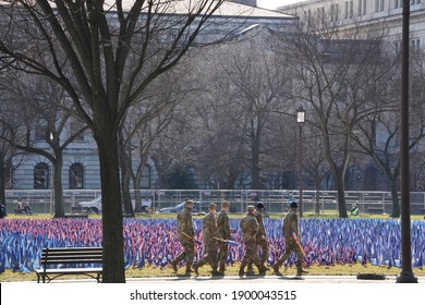 Washington, DC – January 21, 2021: A Group Of National Guardsmen Walking Past Some Of The Flags Used To Decorate The National Mall For The Biden Inauguration.