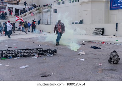 Washington, DC - January 6, 2021: Trump Supporter Walks By Tear Gas Grenade In Front Of Capitol Building Where Pro-Trump Supporters Riot And Breached The Capitol