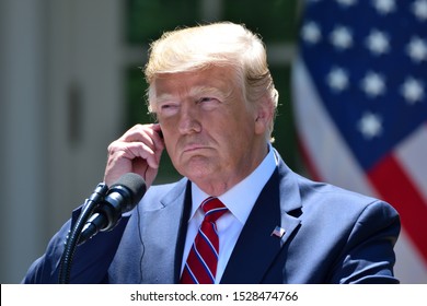 WASHINGTON, DC - JUNE 12, 2019: President Donald Trump adjusts his translation earpiece at a joint press conference with Polish President Andrzej Duda in the White House Rose Garden.
