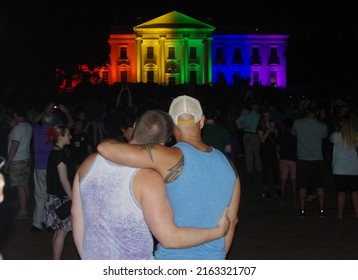 WASHINGTON, DC - June 26, 2015: A Couple Embraces As They Look At The White House Illuminated In Rainbow Colors To Celebrate The Landmark Obergefell Decision Legalizing Gay Marriage.