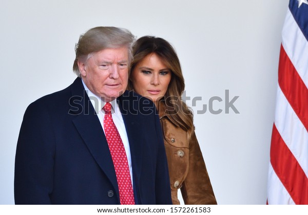 WASHINGTON, DC - NOVEMBER 26, 2019: President\
Donald Trump and First Lady Melania Trump walk into the White House\
Rose Garden from the Oval Office during the annual Thanksgiving\
Turkey Pardon.