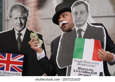 Washington, DC – October 13, 2021: A Protester Dressed As Rich Uncle Pennybags At The IMF Annual Meeting Holds Cash In Front Of Boris Johnson While Italian Prime Minister Mario Draghi Stands By.