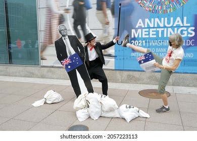 Washington, DC – October 13, 2021: A Protester Dressed As Rich Uncle Pennybags Outside Of The IMF Annual Meeting Holds A Cutout Of Australia's Scott Morrison As An Activist Kicks At Him.