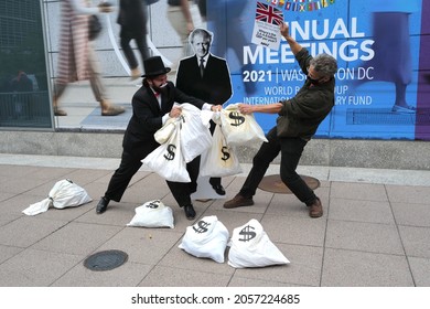 Washington, DC – October 13, 2021: A Protester Dressed As Rich Uncle Pennybags Fights Over Bags Of Money With An Activist As Boris Johnson Watches Outside Of The IMF Annual Meeting.