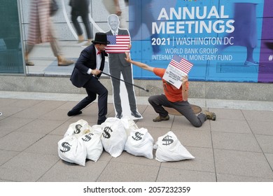 Washington, DC – October 13, 2021: A Protester Dressed As Rich Uncle Pennybags Fights Over Bags Of Money With An Activist As Joe Biden Watches Outside Of The IMF Annual Meeting.