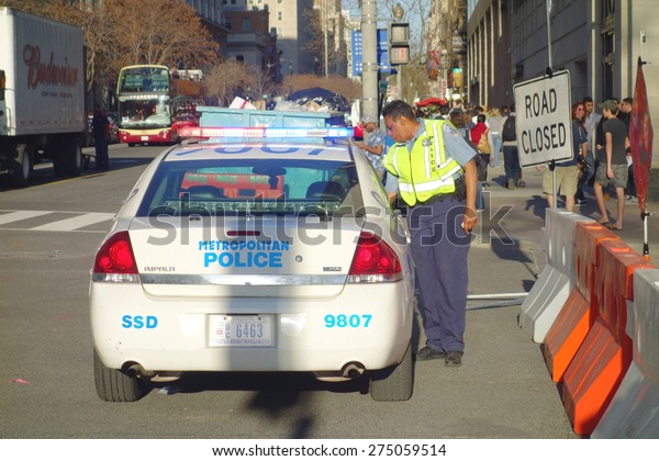 WASHINGTON DC, UNITED STATES OF AMERICA - APRIL\
11, 2015: A Washington DC Metropolitan Police cruiser and and\
officer in a central street of the\
city.