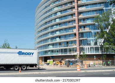 Washington, DC US - June 16 2022: A New Commercial Residential Building In The Final Phase Of Construction On The Wharf Southwest DC Waterfront With Workers On The Balcony And A Truck Out Front