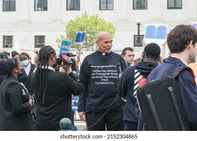 Washington, DC US - May 3, 2022: An Anti LGBTQ Protestor Wearing Catholic Priest Collar And A Shirt With Printed Hate Speech Talks To A Citizen Reporter Outside Of The Supreme Court Building