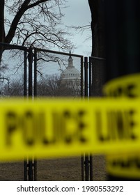Washington, DC, USA - 16 January, 2021: US Capitol Building ahead of the Inauguration of Joe Biden as the 46th US President - seen through Security Fence and with yellow Police Line Tape blurred 