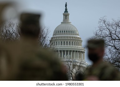 Washington, DC, USA - 16 January, 2021: Dome of the US Capitol Building framed with blurred Silhouettes of US Soldiers ahead of the Inauguration of Joe Biden as the 46th President of the United States
