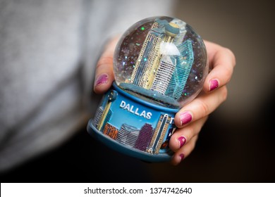 Washington, DC / USA - April 30, 2019: A Woman Holds A Snow Globe Of Dallas, Texas - A Gift From A Souvenir Shop.