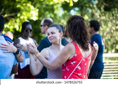 Washington, D.C. / USA - August 12, 2019: Latin Dancers Gather Outside Along The Georgetown Waterfront And Practice Their Bachata, Salsa, Zouk And Kizomba Dancing In A Public Park With A Speaker.