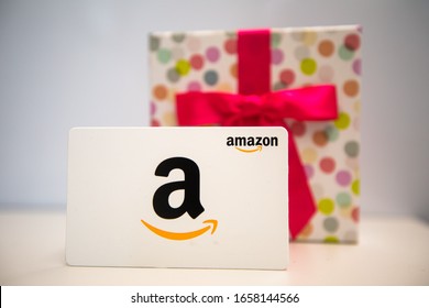 Washington, D.C. / USA - Feb. 26, 2020: An Amazon gift card is taken out of a colorful birthday box. The card can be used to make purchases on Amazon.com. 